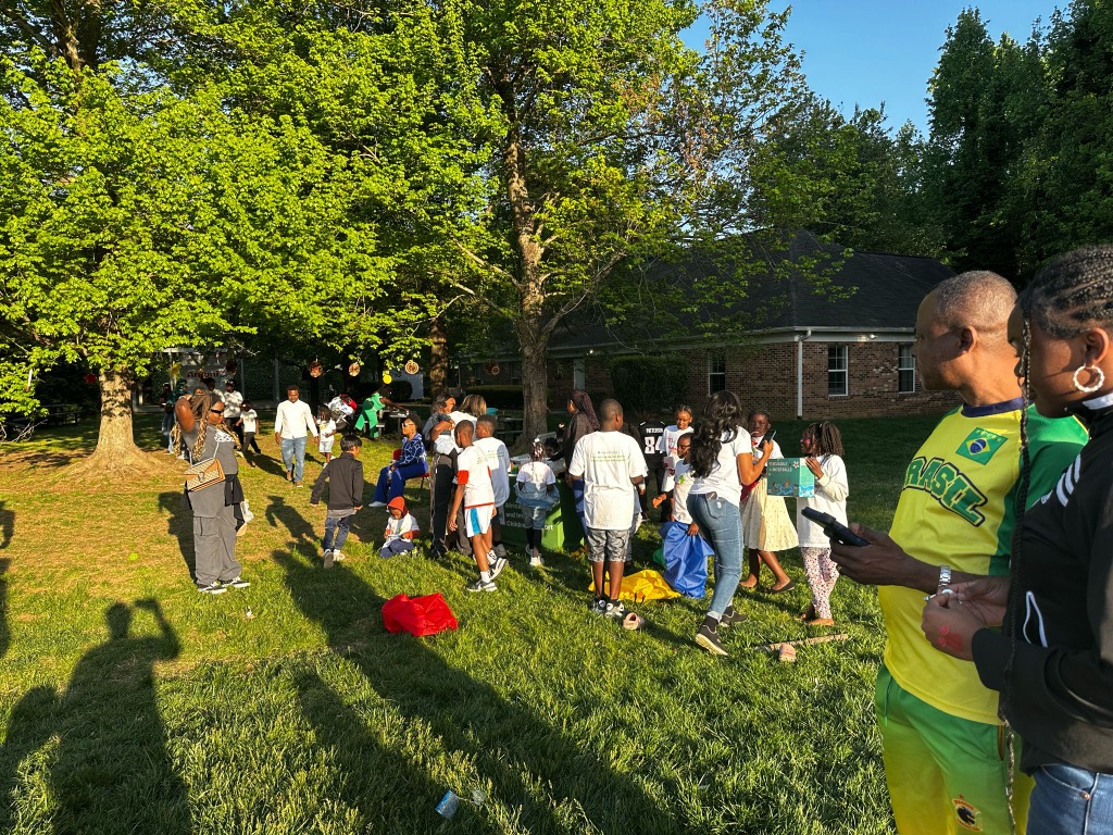 African newcomer families and community members gathering on the lawn during Bisakana Day