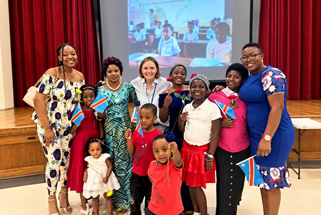 Amani Connect newcomer families, children with flags, and mentors in Charlotte NC